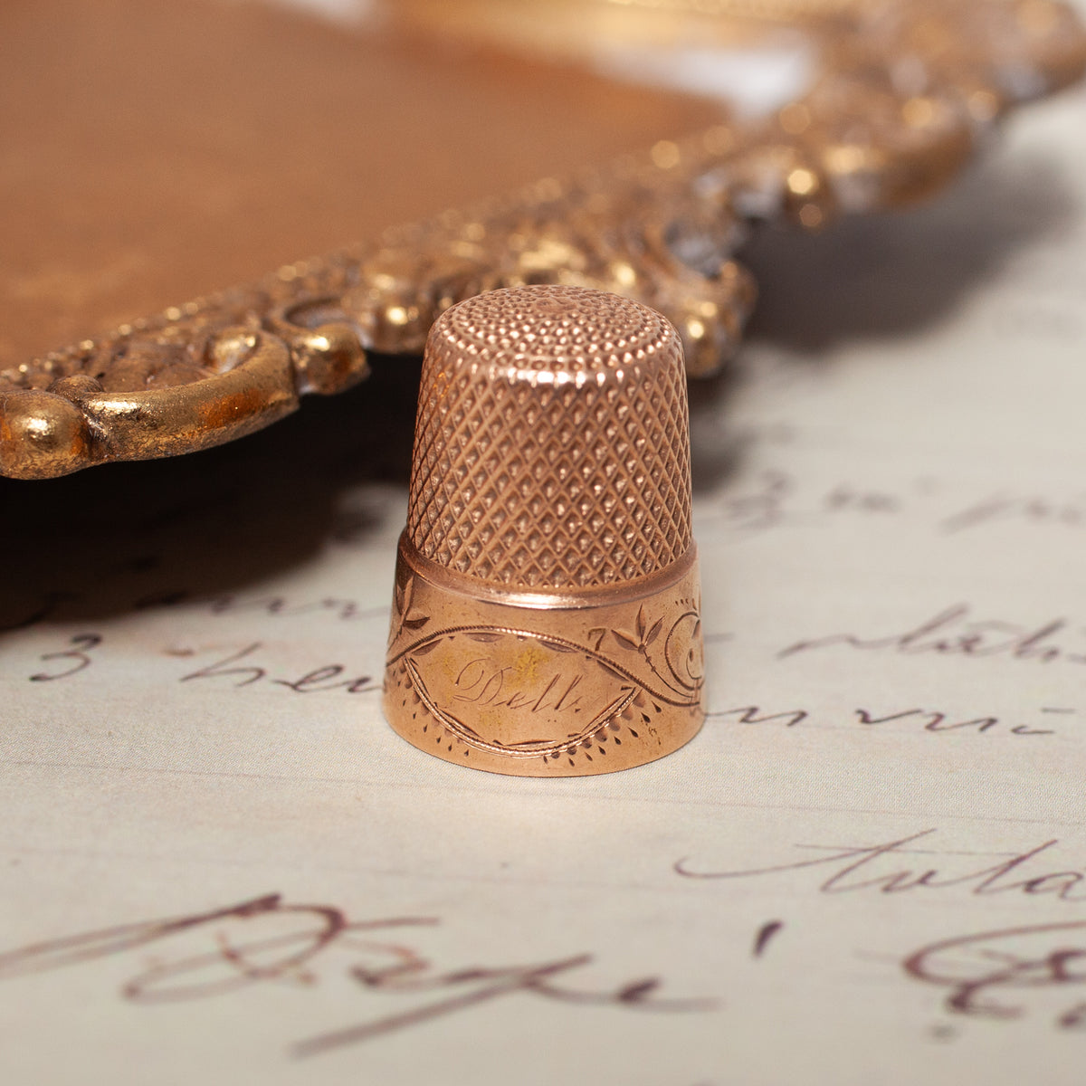 Vintage Engraved Thimble in 14k gold with an engraved floral pattern and the name Dell on the side.