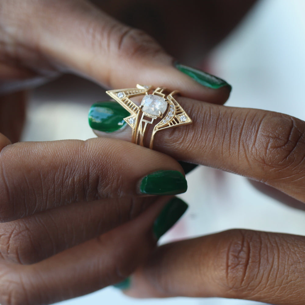  Close up of one hand putting three Fiat Lux gold and diamond rings together in a stack on the middle finger of a second hand
