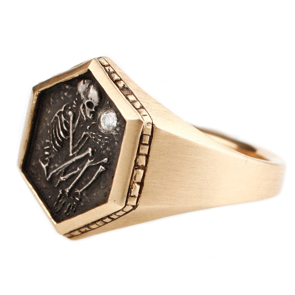 A left-side profile of the shallow grave ring in 14k yellow gold by DMD is centered on a white background
