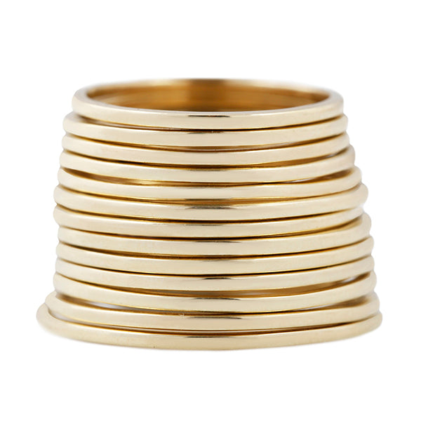 Thirteen stacked full cut 10k gold rings on a white background