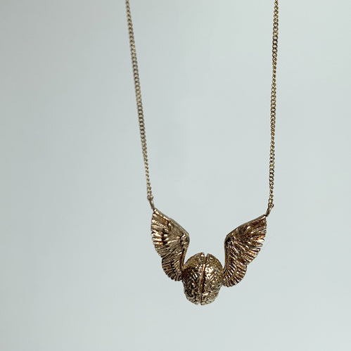 flying brain necklace free hanging on a white background