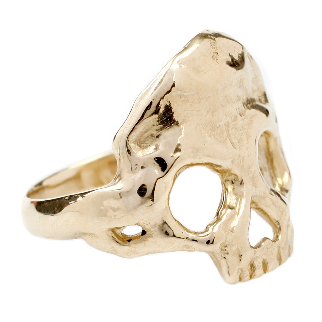 dust to dust gold skull ring by maragaret cross turned on a side profile to the right on a white background